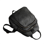 Black backpack with a small black object on a white background