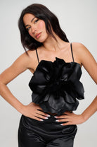 Vacation outfit for women featuring a black floral statement top with thin straps and matching black pants
