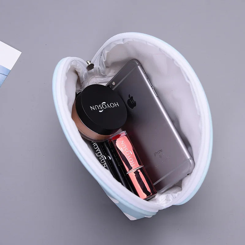 Light blue makeup bag with organized cosmetics and a smartphone