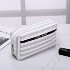 Striped makeup bag in white and gray, perfect for organizing cosmetics
