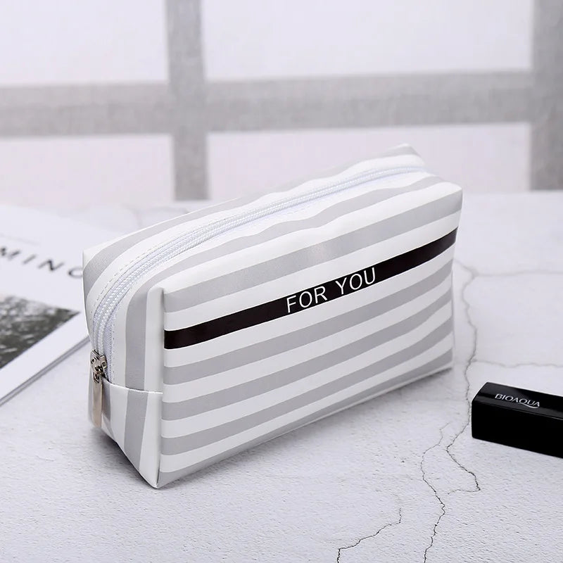 Striped makeup bag in white and gray, perfect for organizing cosmetics