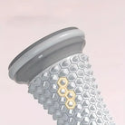 Gray manual foot massager roller with textured grip for relaxation