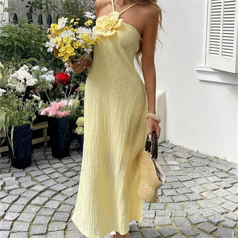Yellow women's sundress with flower detail, perfect for summer outings and maxi dress.