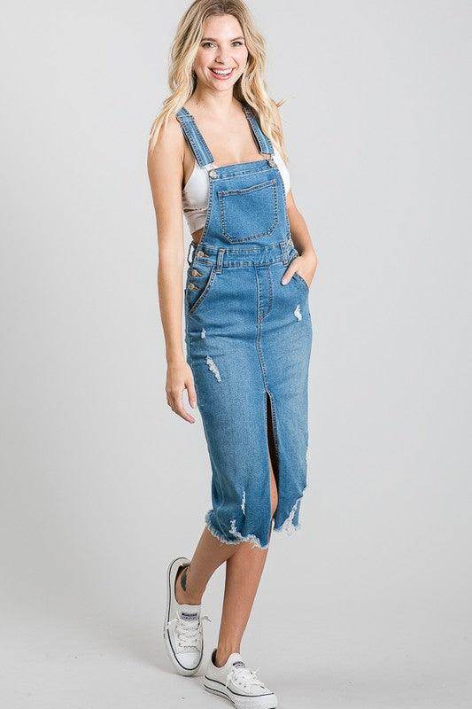 Stylish medium blue overall dress with a split hem and pockets, perfect for casual outings