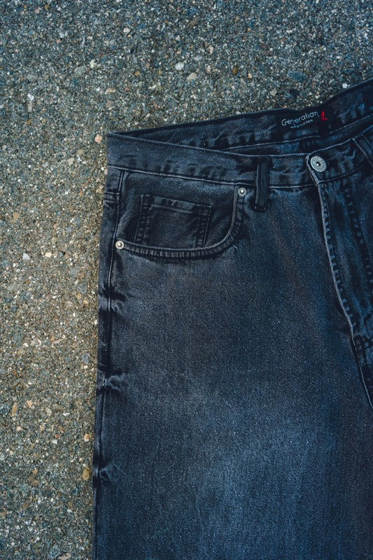Generation XYZ black mens baggy fit jeans showing front pocket and button detail on textured ground
