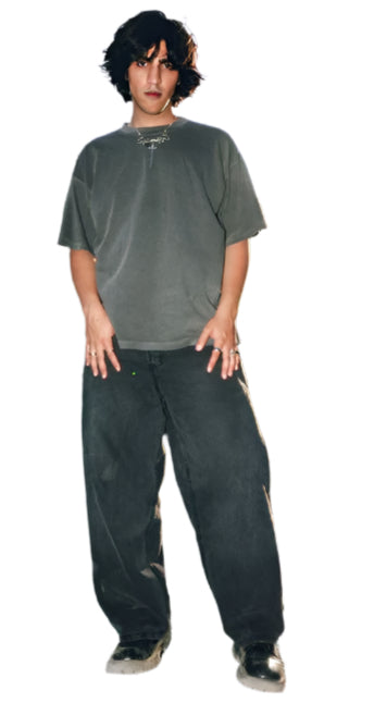 Young man wearing Generation XYZ mens baggy fit jeans and a loose dark gray t-shirt outdoors