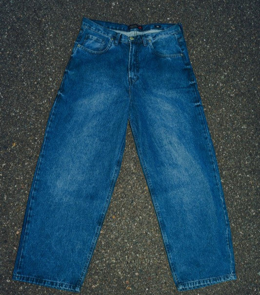 Generation XYZ mens baggy fit jeans in blue denim laid flat on asphalt background