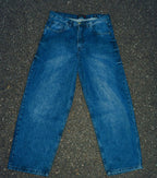 Generation XYZ mens baggy fit jeans in blue denim laid flat on asphalt background