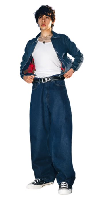 Young man wearing Generation XYZ mens baggy fit jeans paired with a white shirt and denim jacket outdoors
