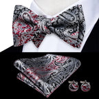 Mens bow tie in red and black paisley pattern with matching pocket square and cufflinks