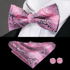 Mens bow tie in pink paisley pattern with matching pocket square and cufflinks