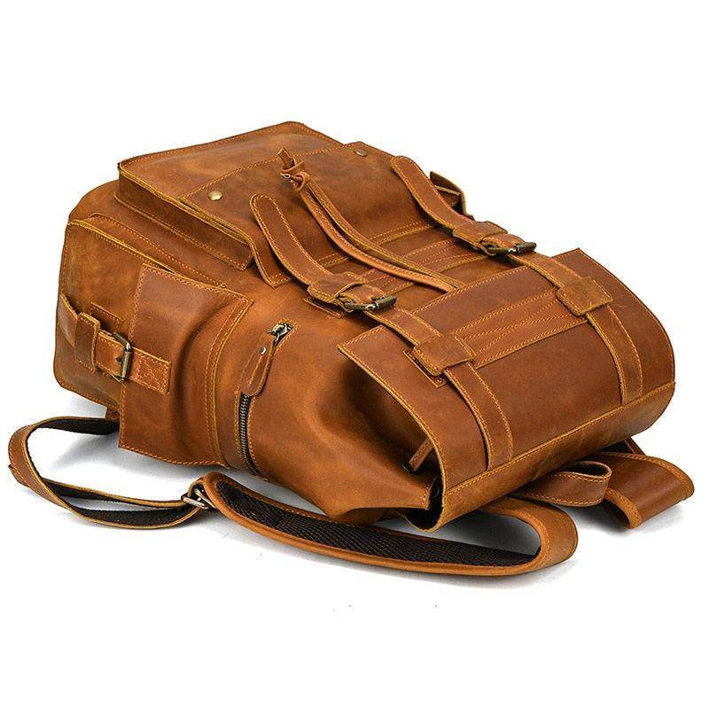 Mens brown leather backpack with multiple compartments and adjustable straps for travel and everyday use