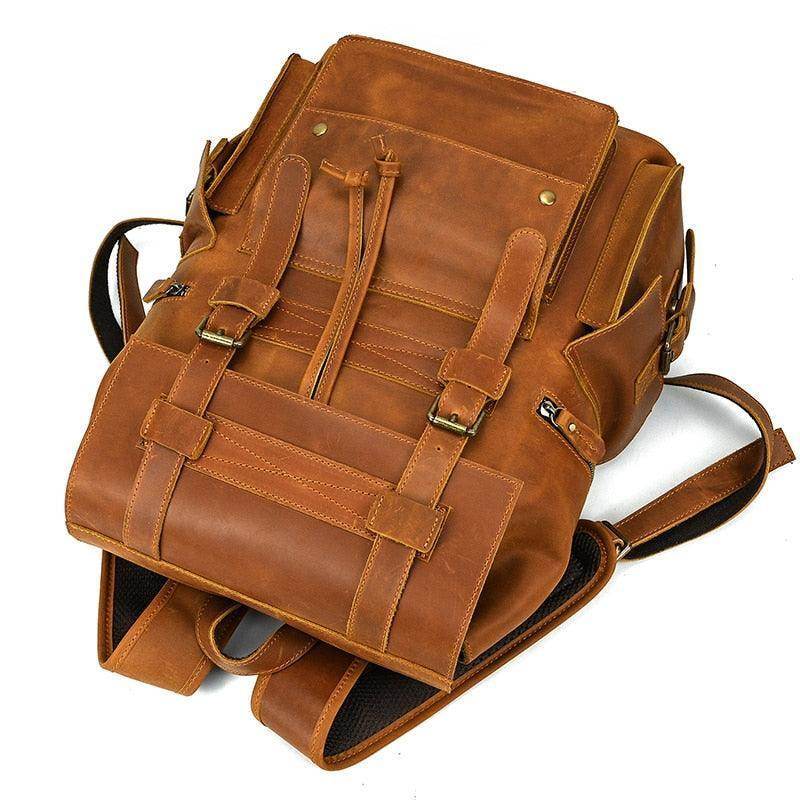 Mens brown leather backpack with spacious compartments and stylish buckle design for daily use