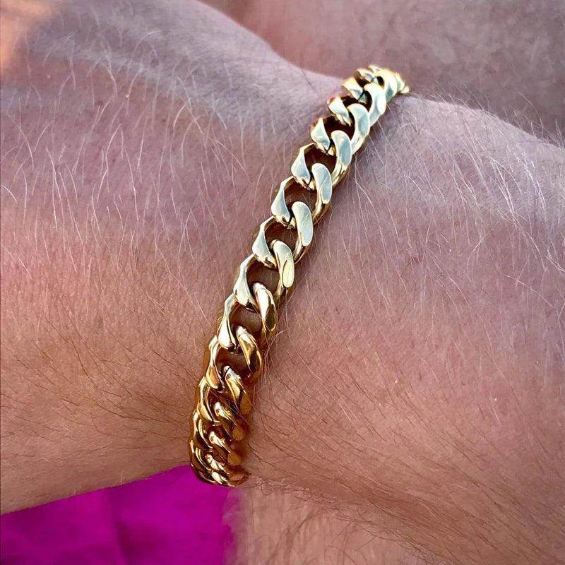 Stylish men's Cuban chain bracelet in gold on a wrist for fashionable accessories
