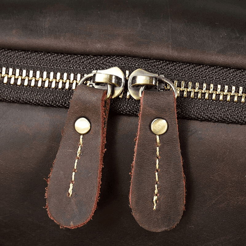Close-up of durable zippers on the mens leather laptop backpack from VacationGrabs
