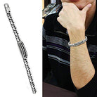 Men's polished steel bracelet featuring a stylish design worn on a wrist