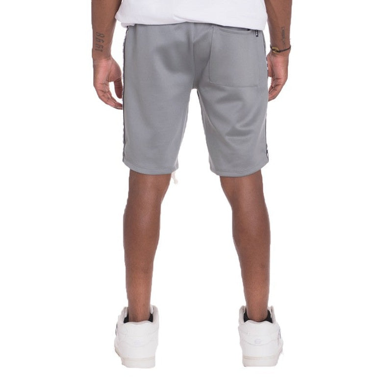 Back view of a man wearing gray mens side tape checkered shorts with white sneakers