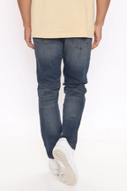 VacationGrabs mens slim fit jeans vintage blue worn by man showing back view with white sneakers