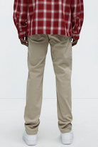 VacationGrabs mens slim fit khaki jeans worn by man with red plaid shirt and white sneakers