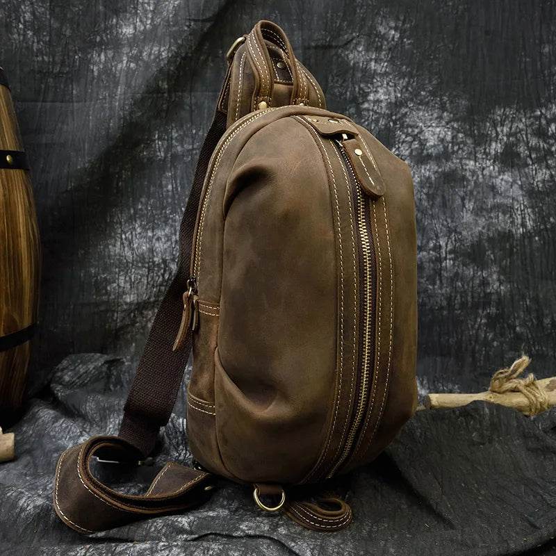 Mens vintage travel chest bag in brown leather with adjustable shoulder strap and multiple pockets