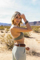 Stylish model wearing a Mesh Dream Catcher Bralette outdoors, paired with high-waisted pants in a desert setting