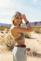 Stylish model wearing a Mesh Dream Catcher Bralette outdoors, paired with high-waisted pants in a desert setting