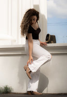 Stylish model wearing women's ankle boots with white pants and a black shirt, showcasing microfiber Chelsea boots for men