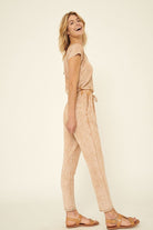 Women's mineral washed knit jumpsuit in soft peach with relaxed fit and adjustable waist for summer style