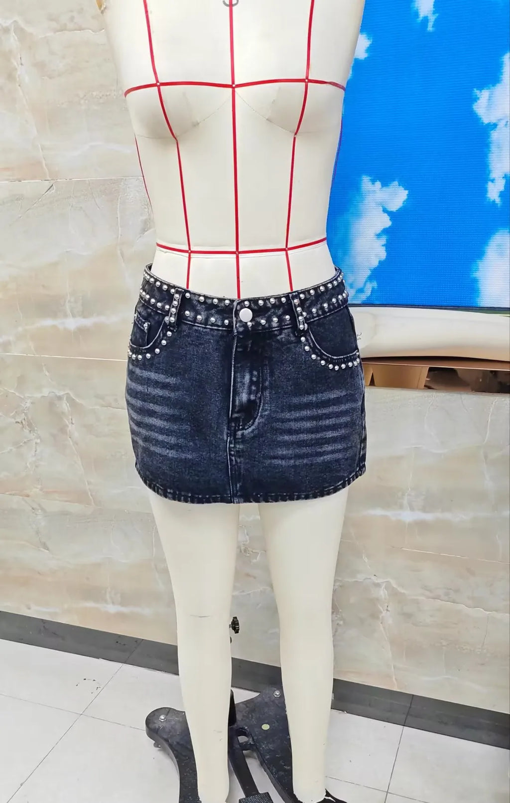 Black denim mini skirt with studs, perfect for casual outings