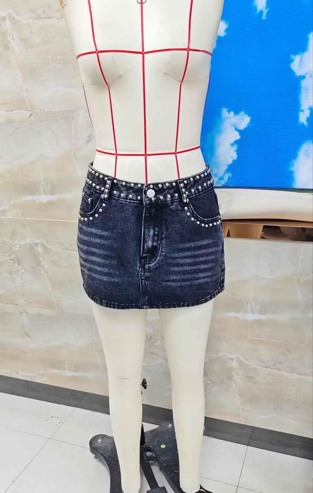 Black denim mini skirt with studs, perfect for casual outings