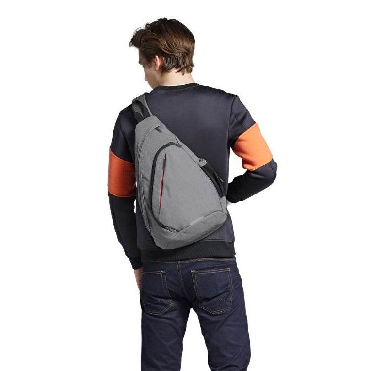 Man wearing a gray USB charging crossbody backpack for stylish and convenient travel.