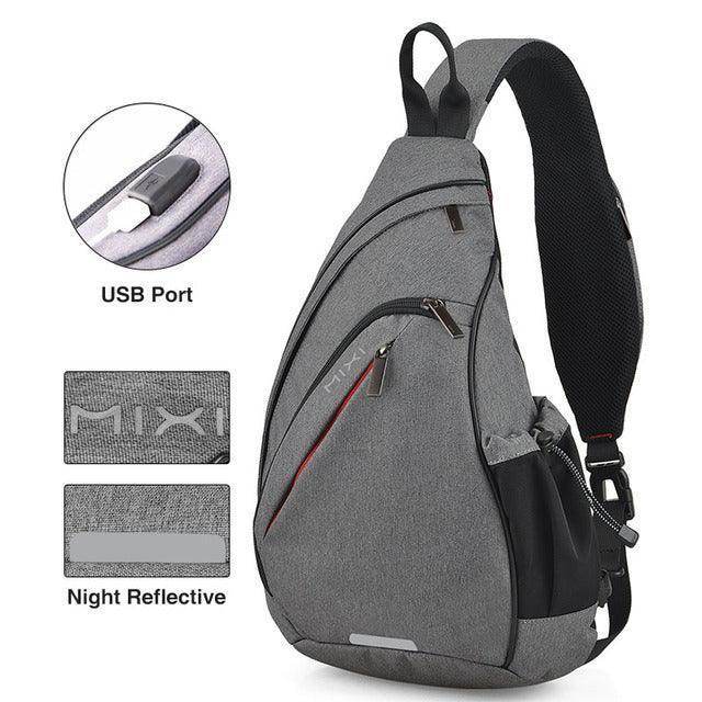 Gray USB charging crossbody backpack with USB port and night reflective features for convenience