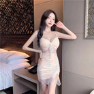 Woman wearing a delicate lace nightclub coquette slip dress with spaghetti straps and a thigh slit
