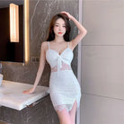 Woman wearing white lace nightclub coquette slip dress with spaghetti straps and front slit