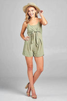 Ivory Felix Women's one-piece romper with open back in green, styled with a sun hat and sandals