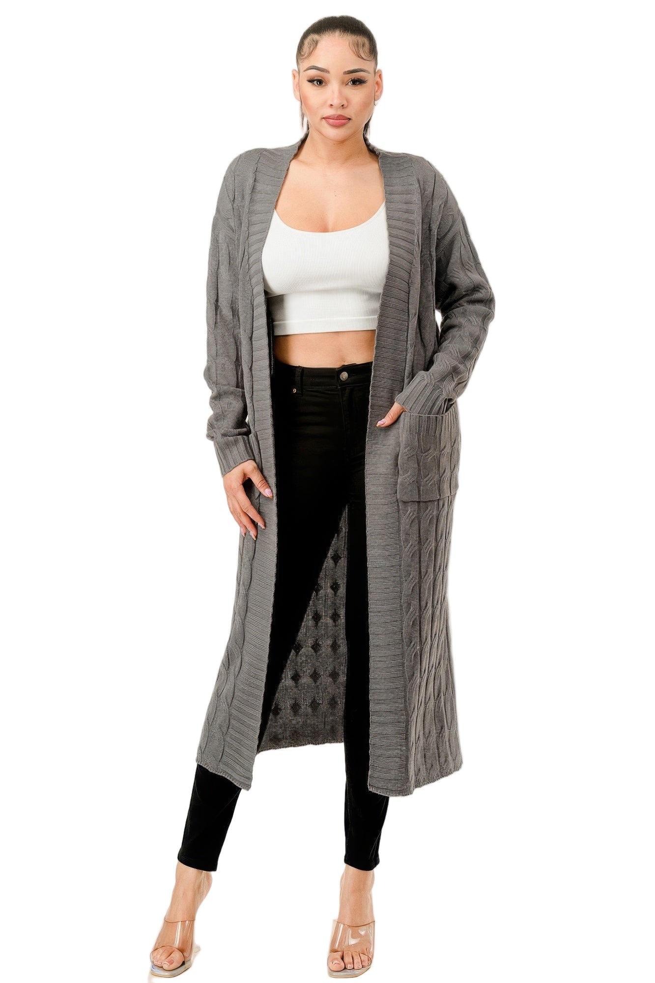 Women's open front cable knit sweater in gray with long sleeves and pockets styled over black jeans