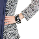 Stylish woman wearing an oversized black crystal bangle on her wrist with a fashionable outfit
