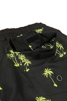 Close-up of WEIV men's swimwear featuring palm tree print swim shorts with vibrant yellow design