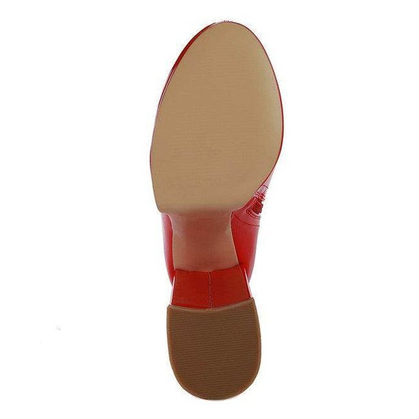 Sole view of red patent leather calf boots showcasing a smooth finish and stylish design