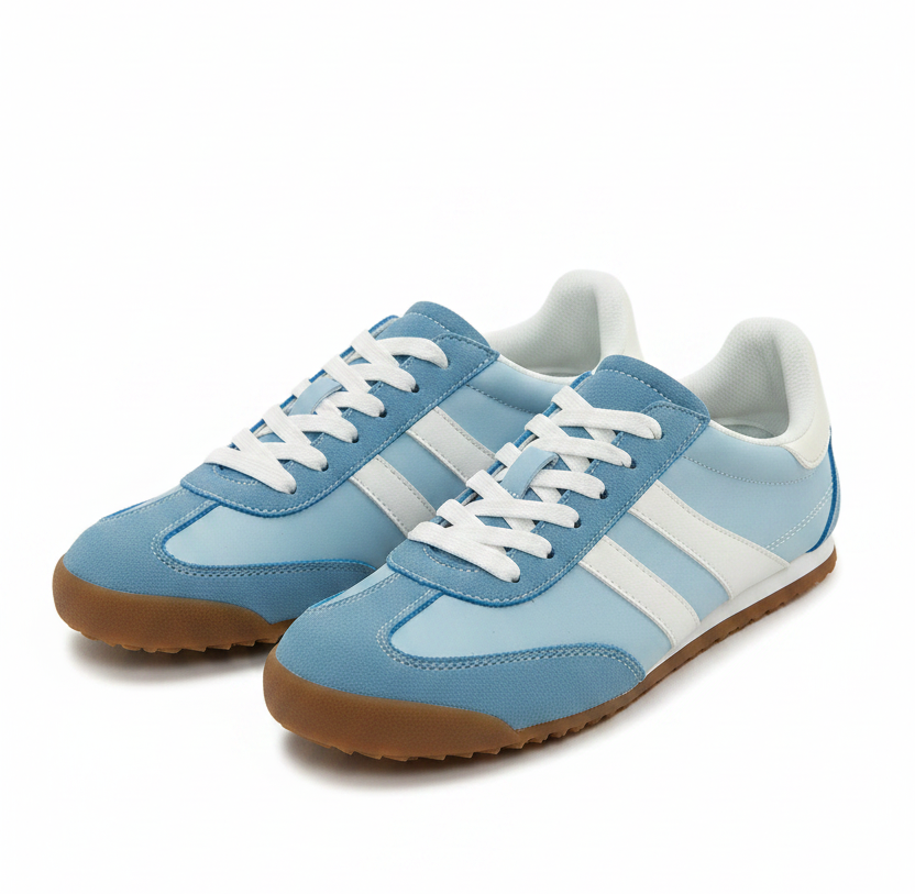 Blue sneakers with white stripes worn with light blue jeans on a white background