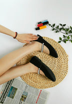 Rag Company pearl detail Mary Jane flats in black worn on feet with woven mat and nail polish