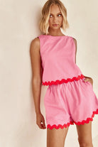 Woman wearing Miss Sparkling casual matching shorts and top set in pink with red trim details