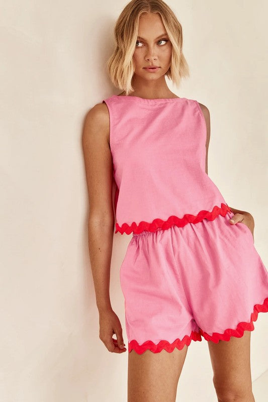 Woman wearing Miss Sparkling casual matching shorts and top set in pink with red trim details