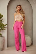 Stylish model in pink high rise trousers paired with a trendy top for a chic summer look