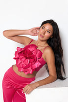 Woman wearing a pink satin crop top and wide leg pants set with floral detail by VacationGrabs