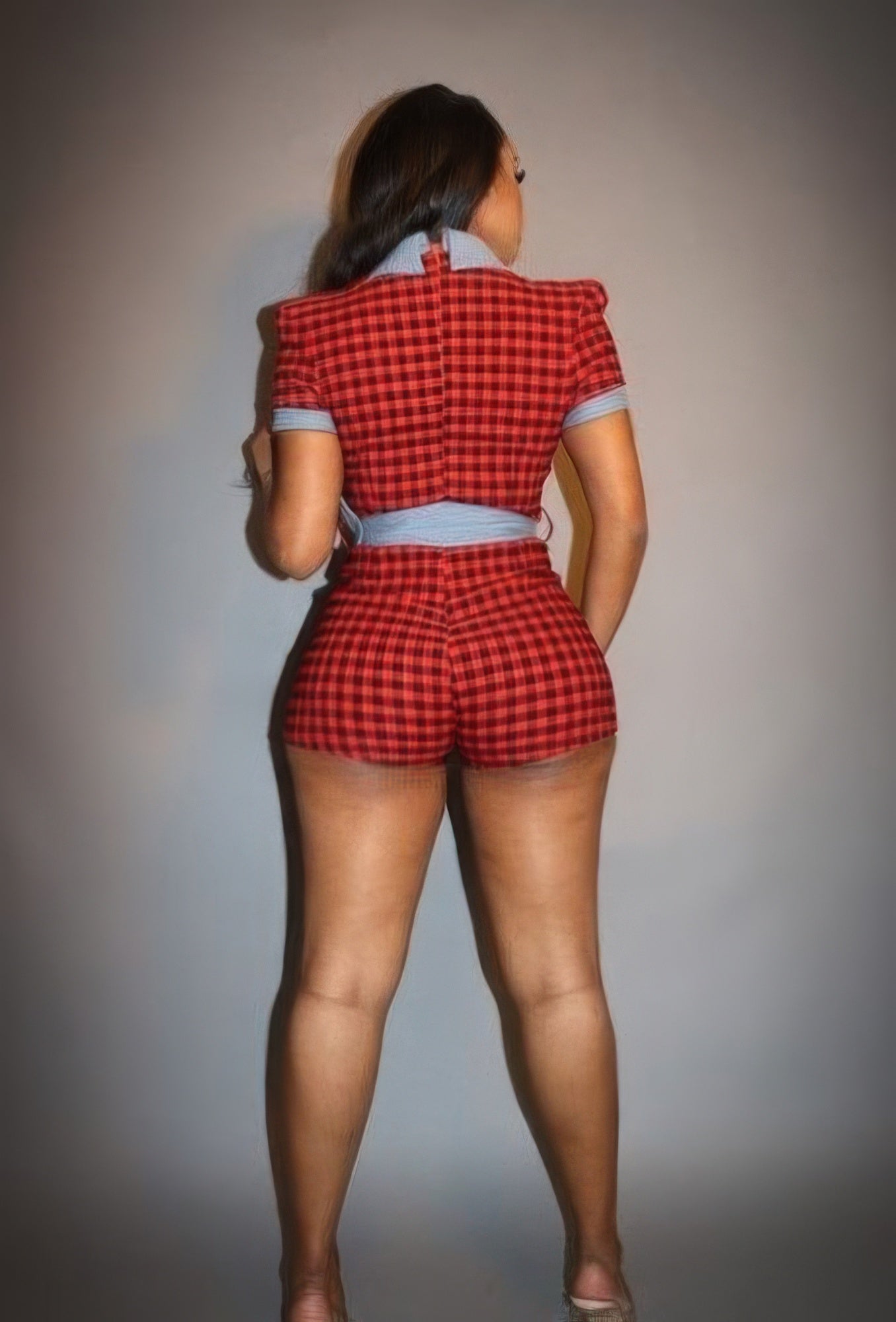 Back view of a stylish plaid denim romper for women with puff sleeves and a fitted design