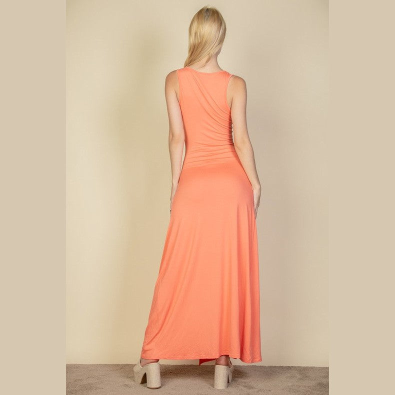 Capella women's plunge neck thigh split dress in coral shown from the back with sleeveless design
