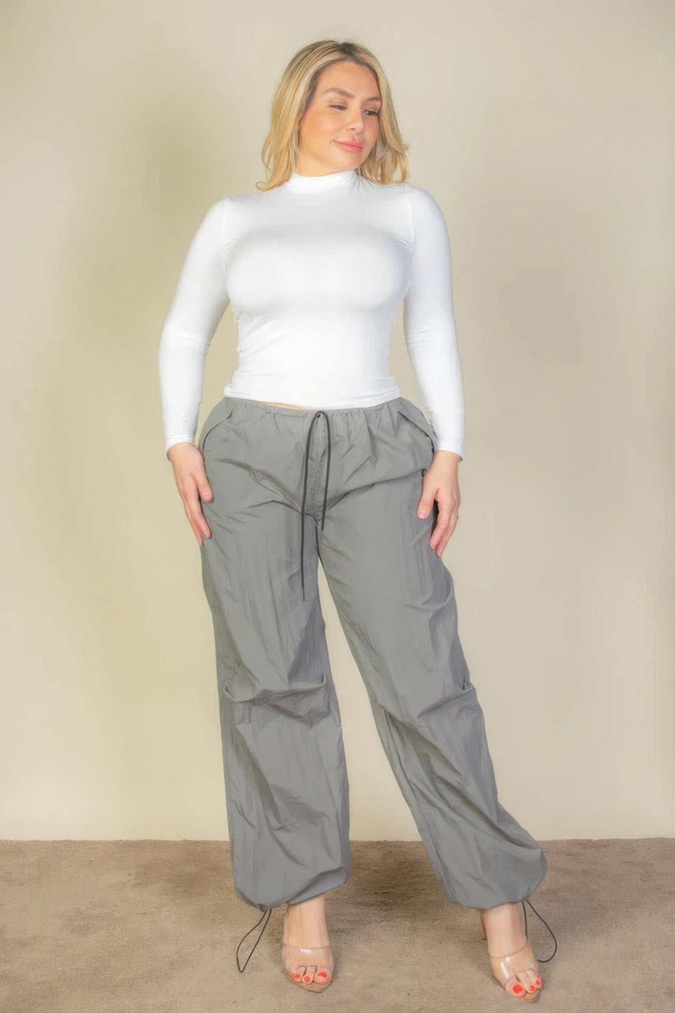 Model wearing gray plus size parachute pants for women with adjustable drawstring and relaxed fit