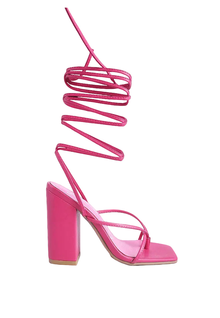 Pink high-heeled sandal with a unique strap design on a white background