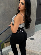 Women's black and white polka dot dots top paired with sleek black jeans